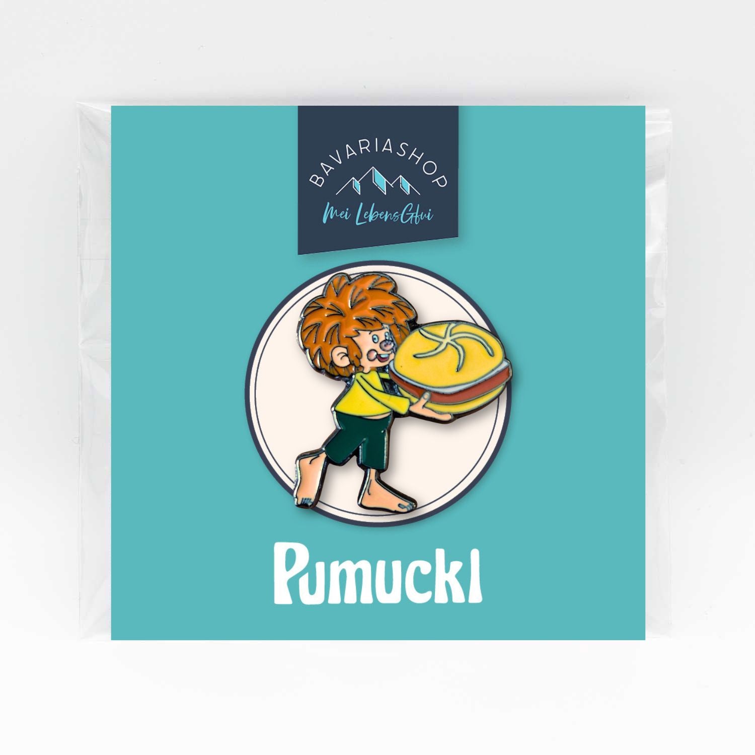 Pumuckl Pin mit rotem Haar, grünem Shirt, der eine Leberkassemmel haltend vor weißem Hintergrund steht