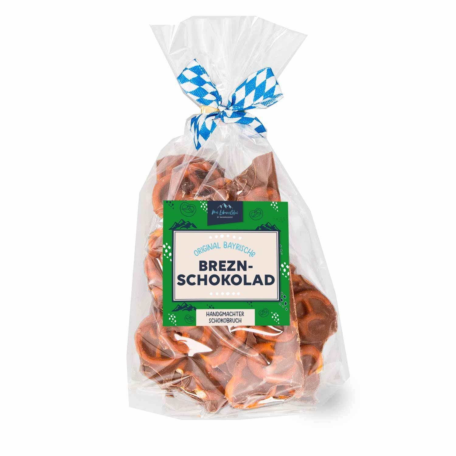 Handgemachter Schoko-Bruch mit braunen Brezelstücken auf unregelmäßiger Tafelform, verziert mit Salzsprenkeln.