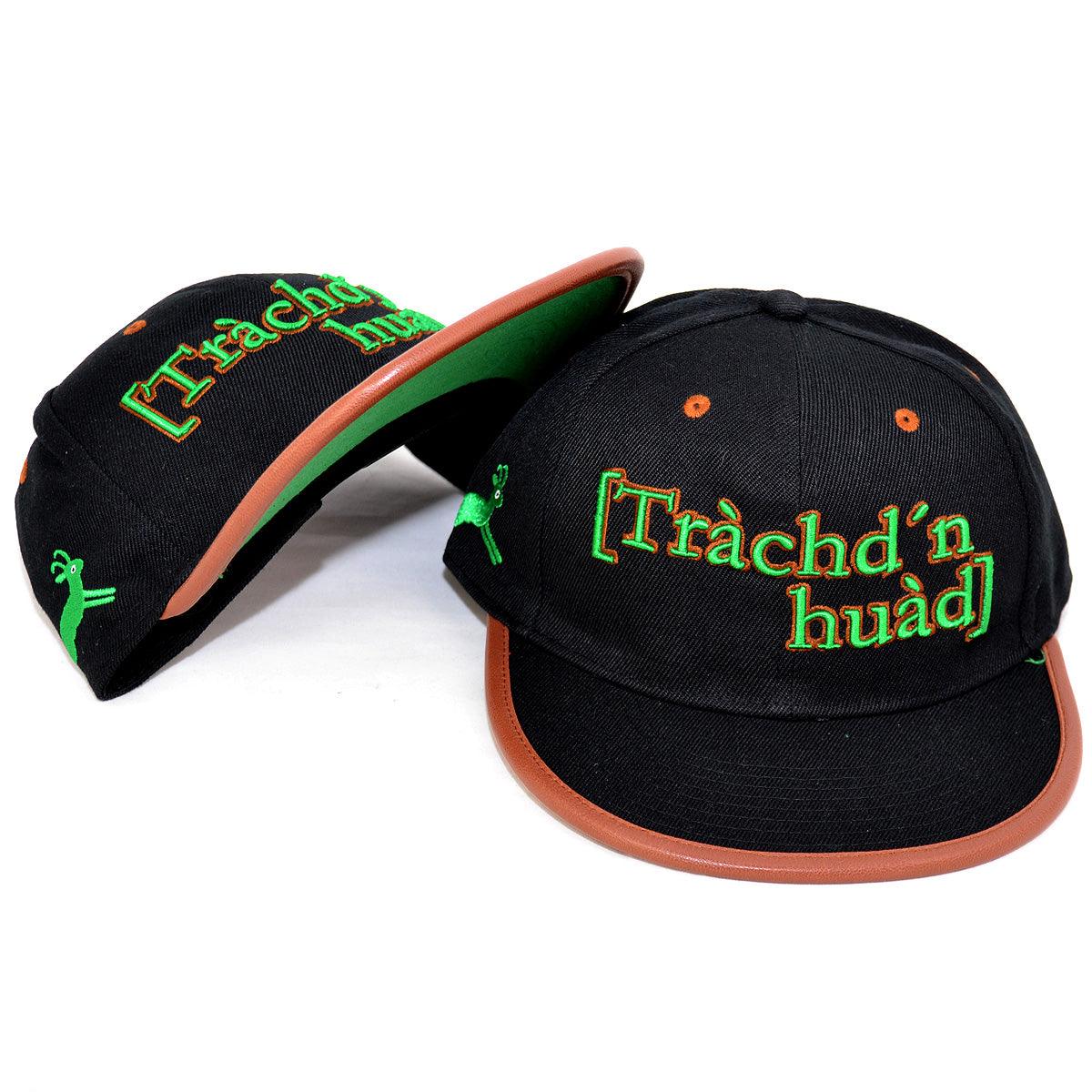 Zwei schwarze Snapback-Caps mit braunem Visor, grün-orange besticktem Schriftzug Tràchd'n huàd und Hirsch-Logo.