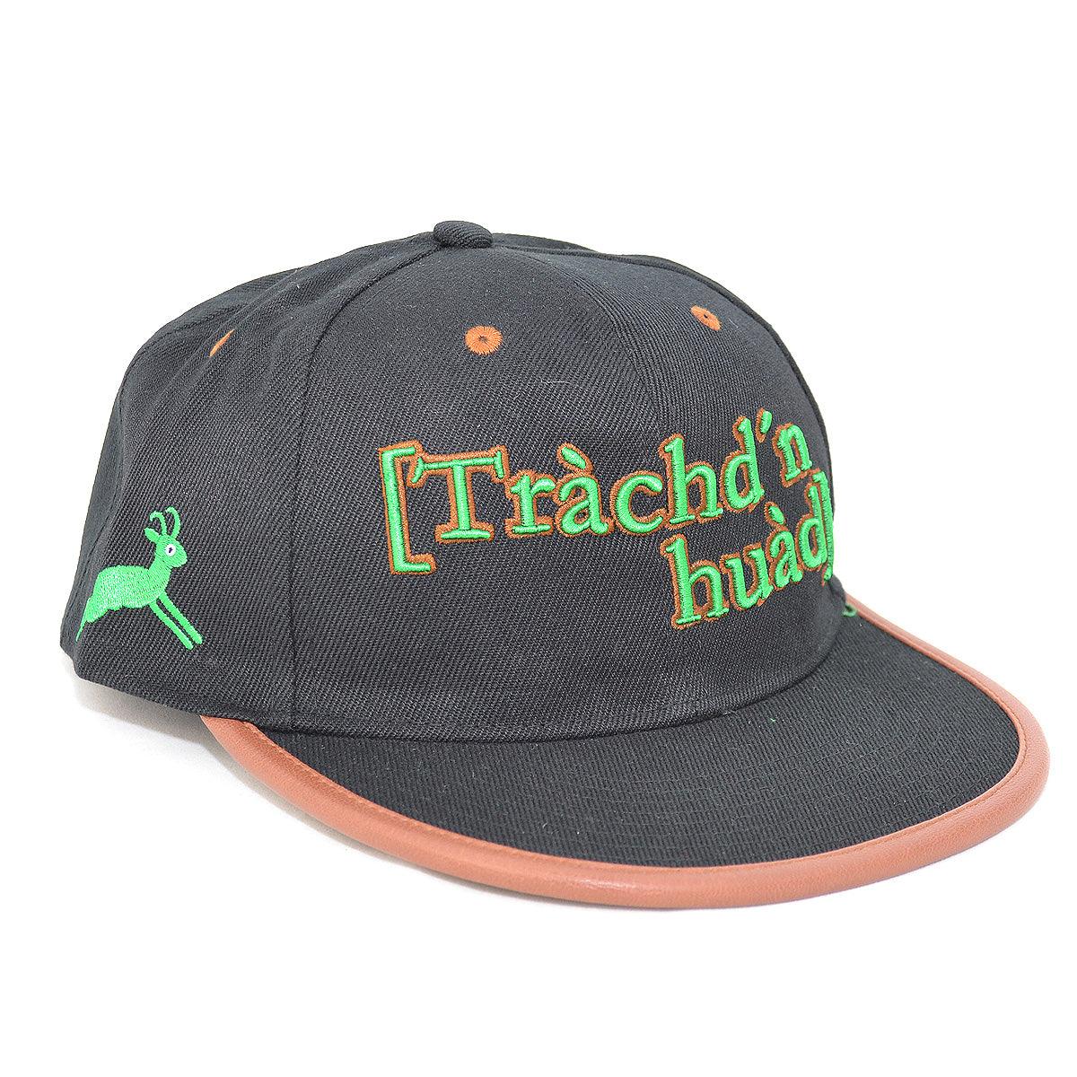 Schwarz-graue Trachten-Cap mit besticktem grünen "Trachd'n huad" Schriftzug, Reh und braunem Schirmrand.
