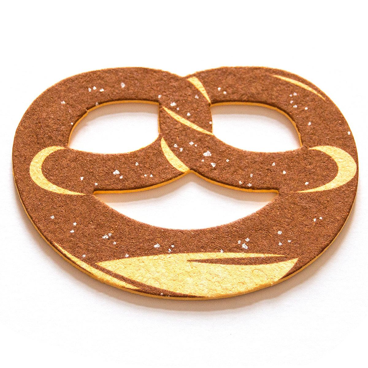 Schwamm in Brezn-Form aus saugfähiger Zellulose, braun mit weißem Salz-Motiv, ca. 10 x 7 cm, waschbar.